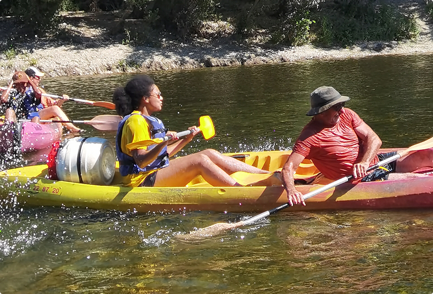 Deux collaborateurs EI Groupe pagayant en kayak sur une rivière lors d'une activité de cohésion d'équipe estivale
