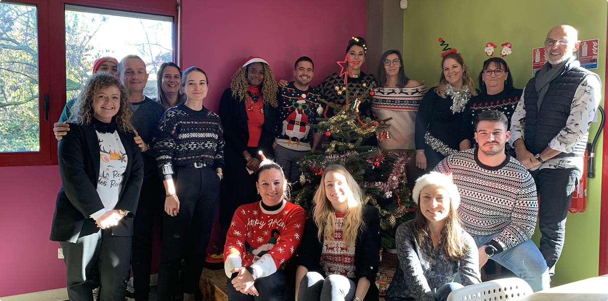 Équipe EI Groupe réunie autour d’un sapin de Noël lors d’un événement interne favorisant la convivialité et l’esprit d’équipe