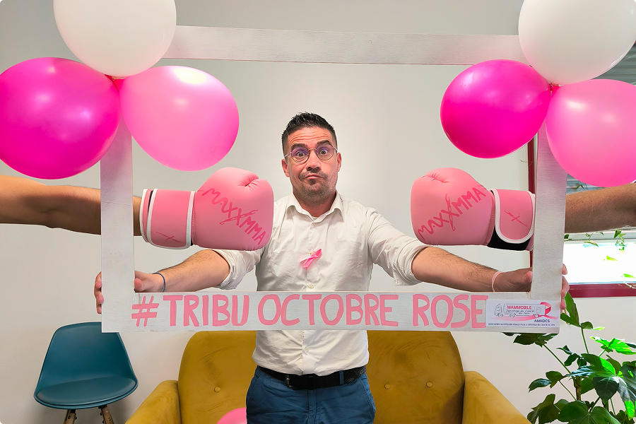 Collaborateur EI Groupe posant avec un cadre « #Tribu Octobre Rose » lors d'un événement de solidarité Octobre Rose